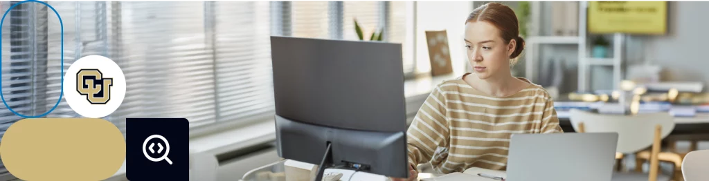 Person at a desk with multiple monitors, icons, and University of Colorado logo in an office